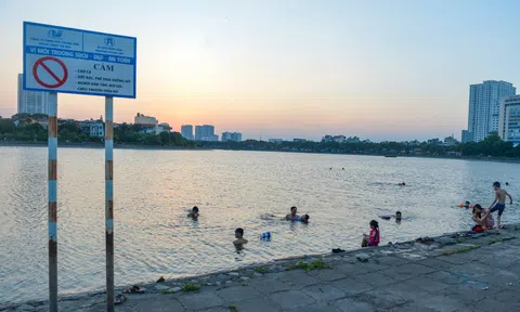 Giữa trời nắng chang chang, bất chấp biển cấm, người dân đội nón bơi ra giữa hồ Linh Đàm