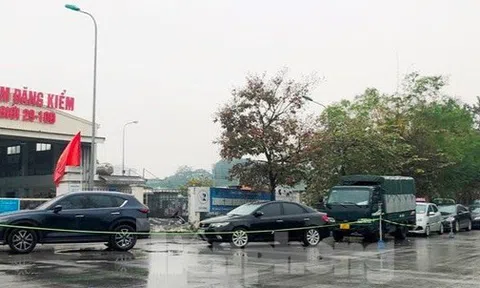 Người dân xếp hàng dưới mưa chờ đăng kiểm ô tô tại Hà Nội