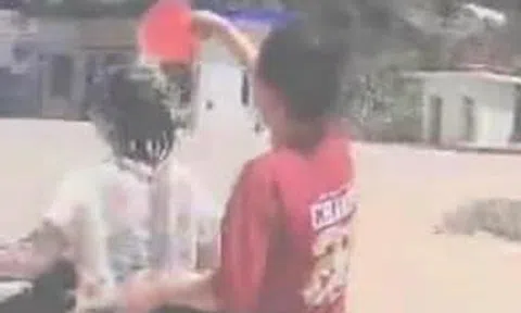 2 thiếu nữ vừa đi xe máy, vừa “tắm” trên đường