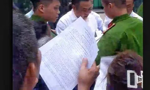 Chủ tịch Hà Nội Trần Sỹ Thanh cúi người nhặt tờ đơn của người dân bị rơi